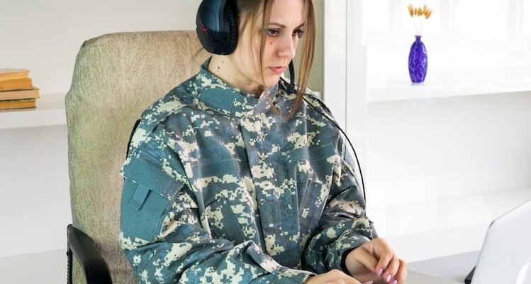 a woman wearing headphones sitting in front of a laptop computer