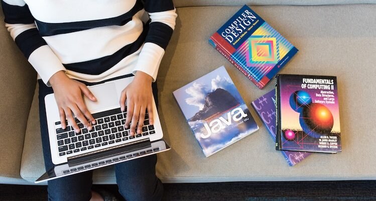 person in white and black striped top using MacBook