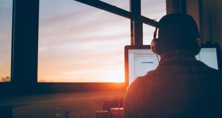 man sitting facing monitor