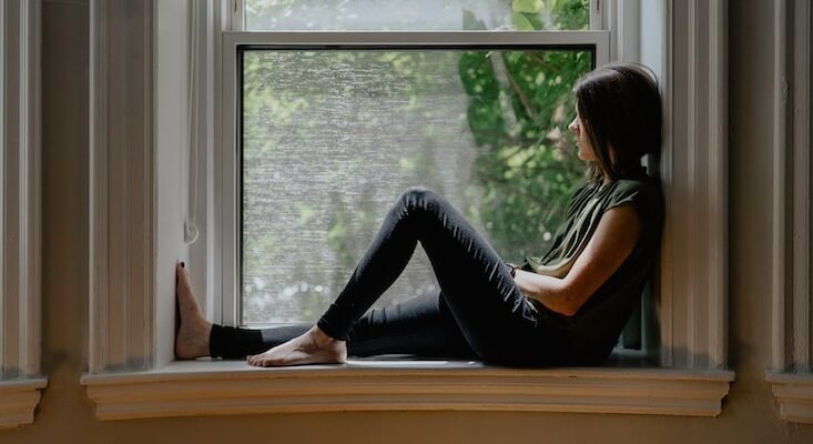 a woman sitting on a window sill